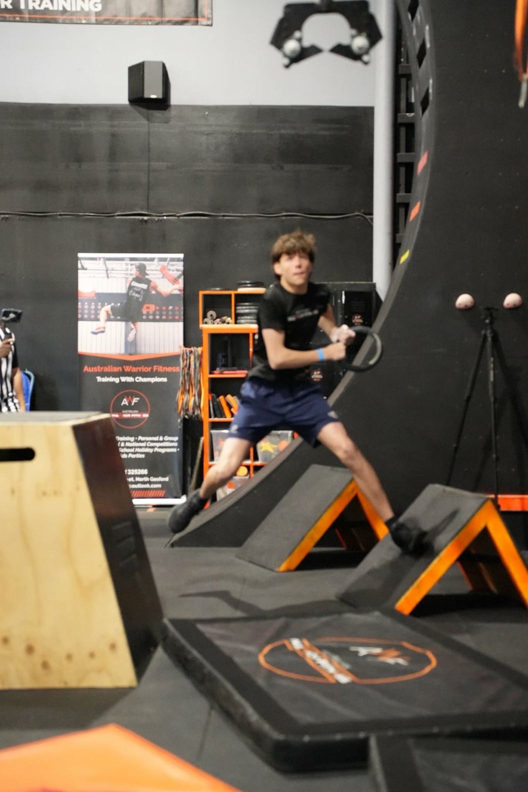 Teen athlete leaping across the angled step obstacles at AWF