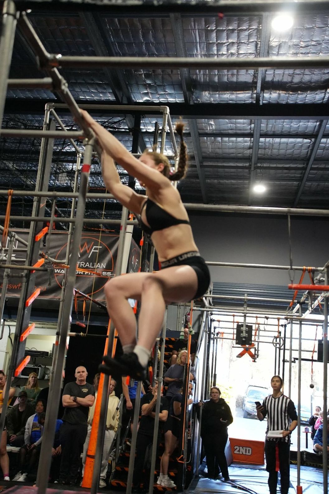 Athlete swinging between bars on the AWF rig during a ninja competition