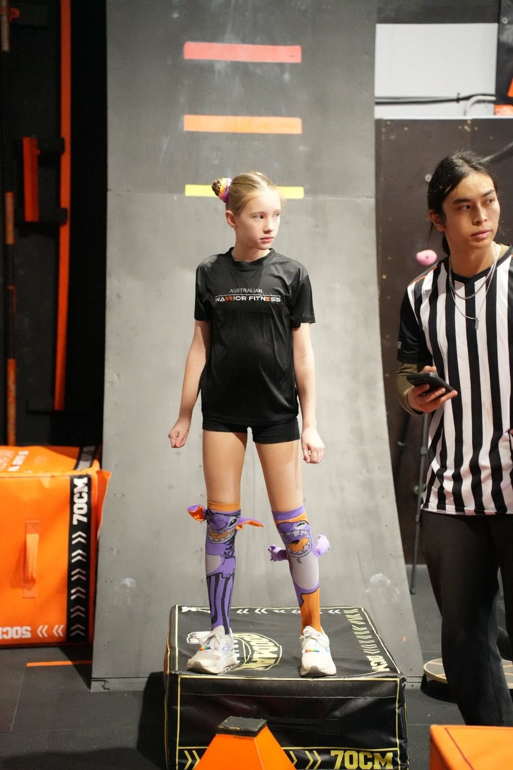 Young athlete on a starting box as a referee watches at AWF