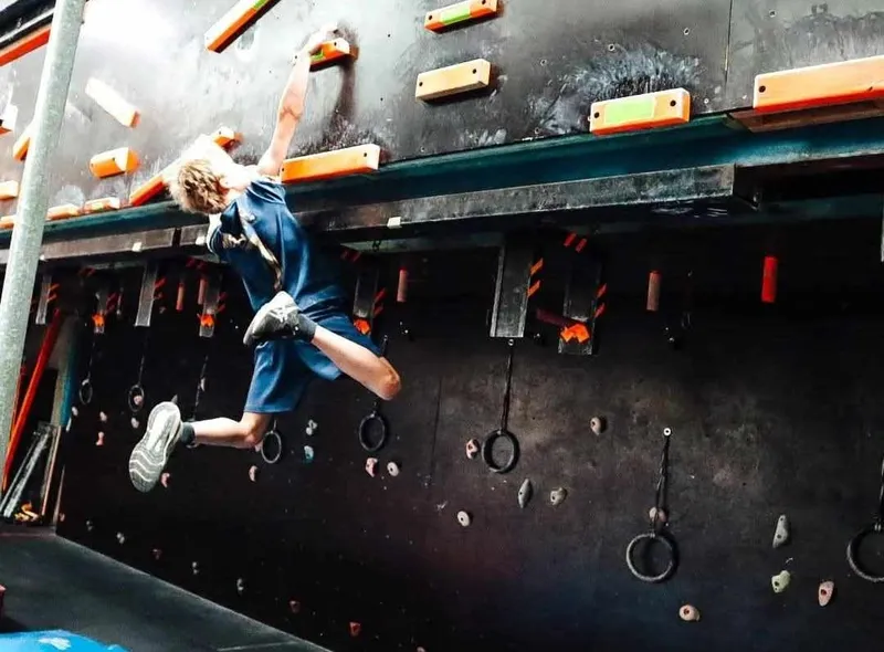 Red-haired girl jumping across an AWF Ninja obstacle